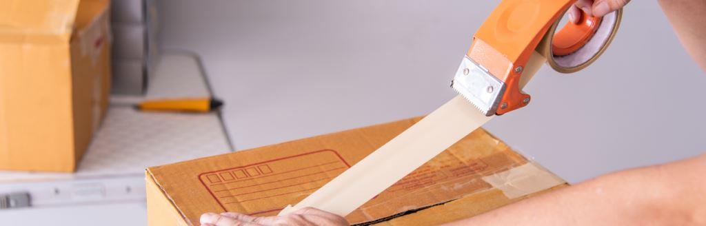 Zaklejanie kartonu taśmą papierową umieszczoną w dyspenserze